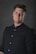A man in a black shirt posing for a picture