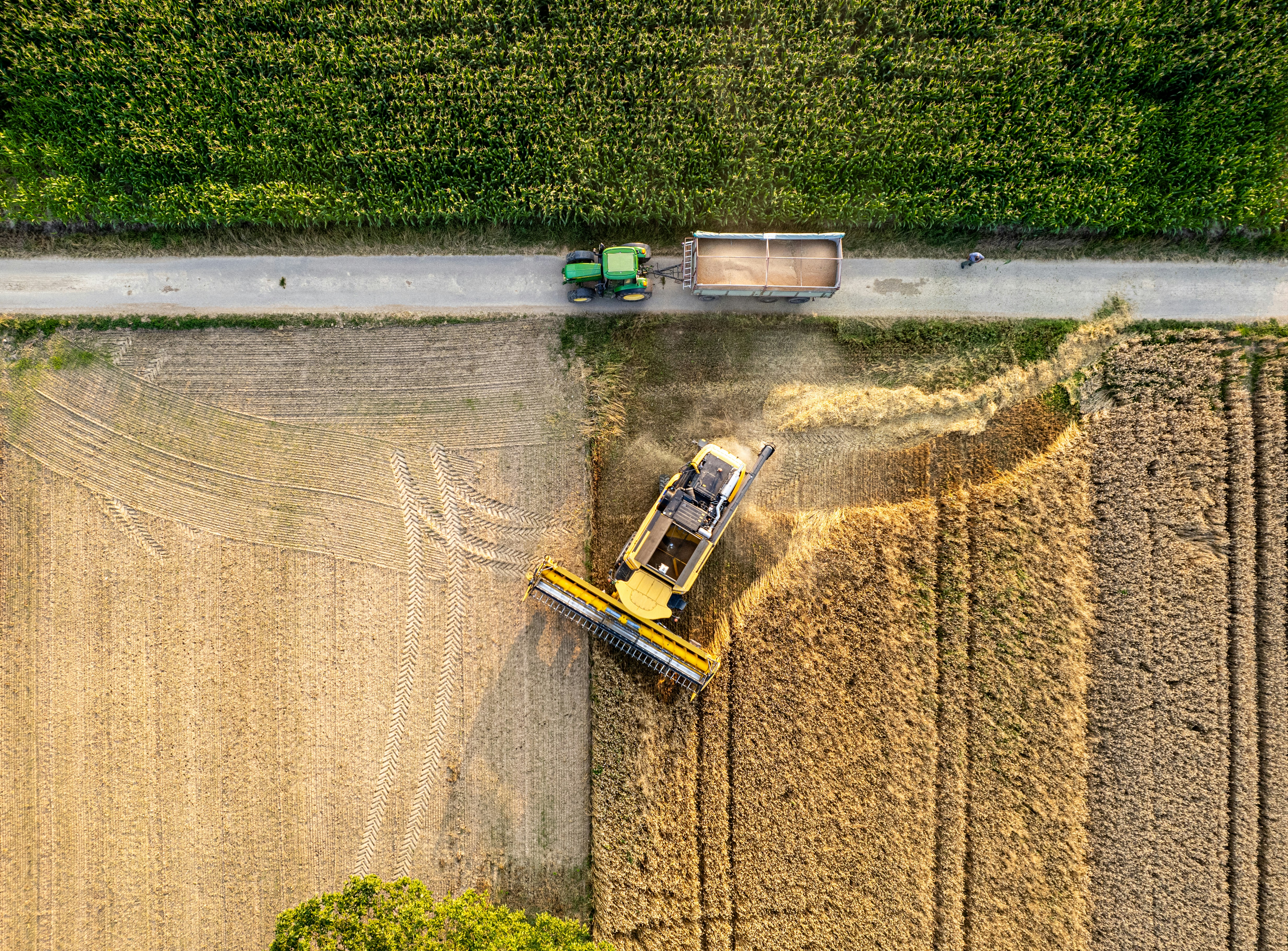 An aerial view of a combineer and a tractor in a field