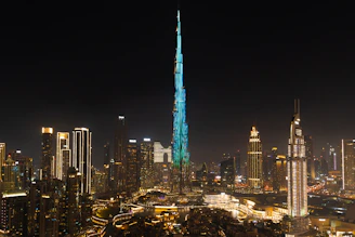 A very tall building towering over a city at night