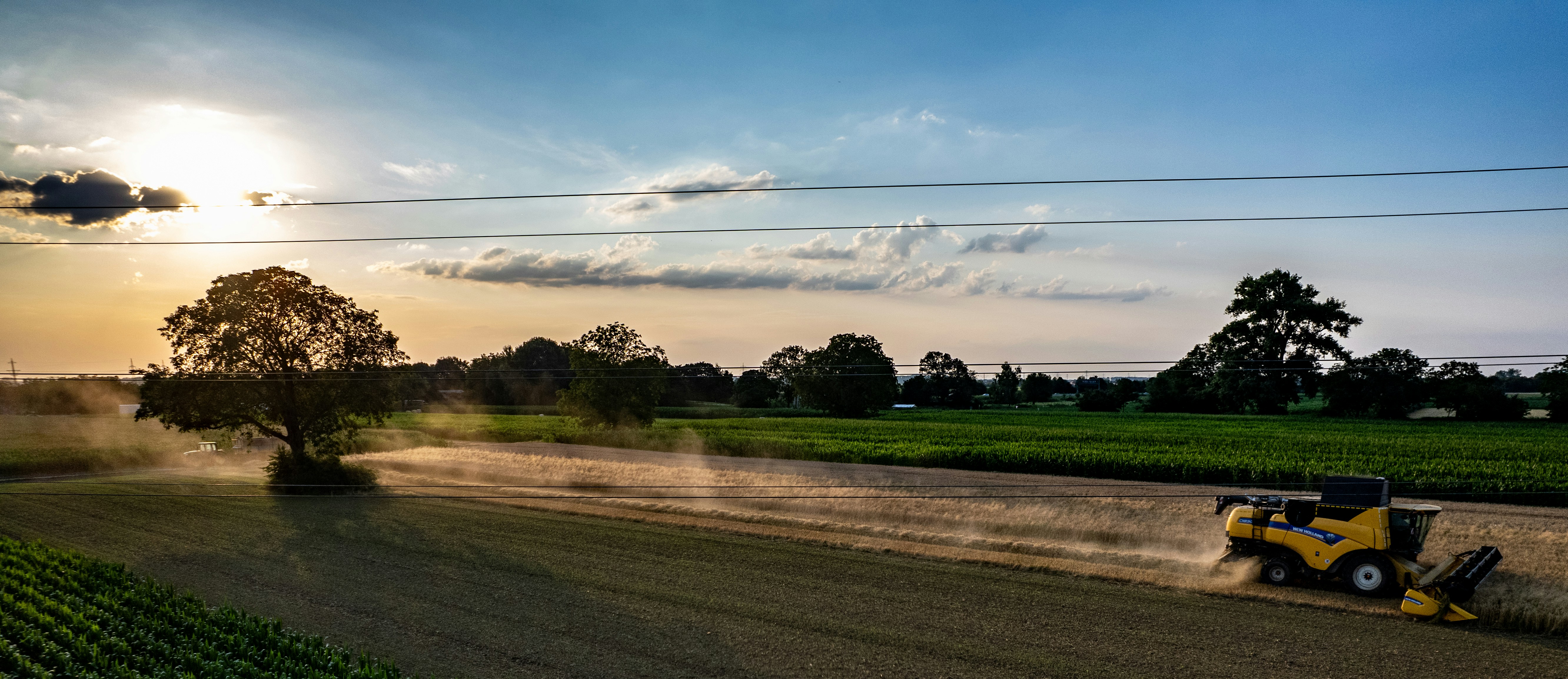 A tractor is driving down a dirt road