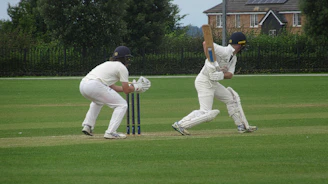 A couple of men playing a game of cricket