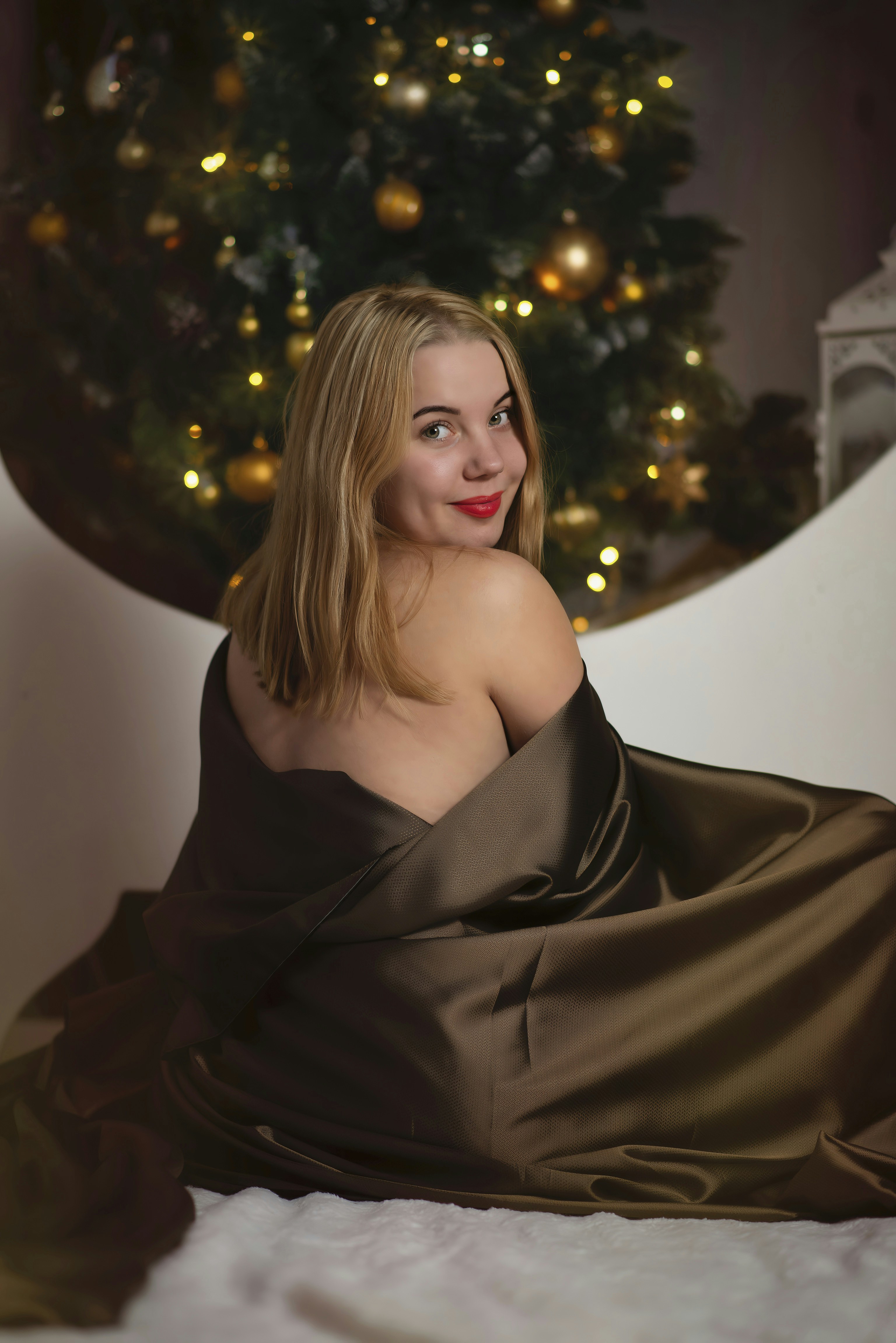 A woman in a brown dress laying on a bed