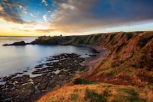 A view of a rocky beach with a sunset in the background