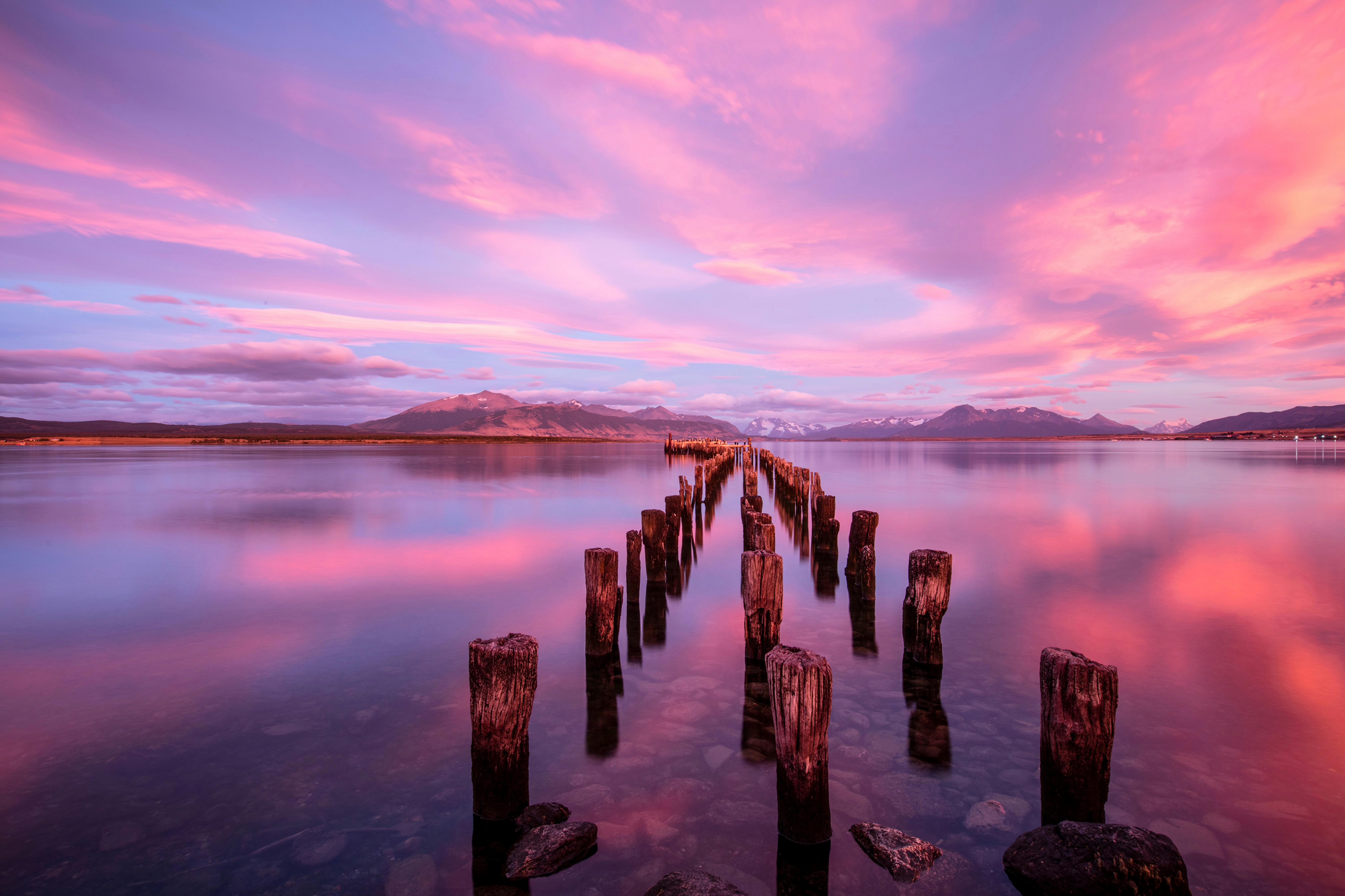 A long dock sitting in the middle of a lake, the colours of a patagonian sunrise