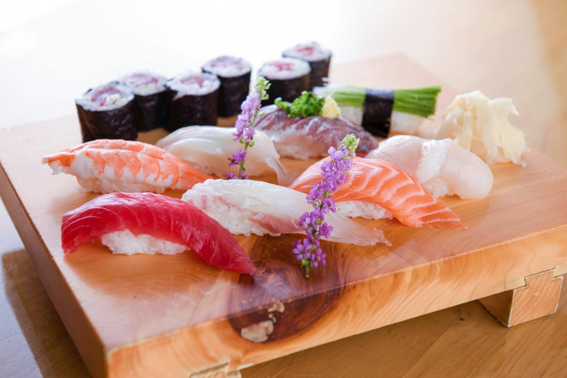 A wooden table topped with lots of sushi