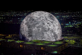A large moon over a city at night
