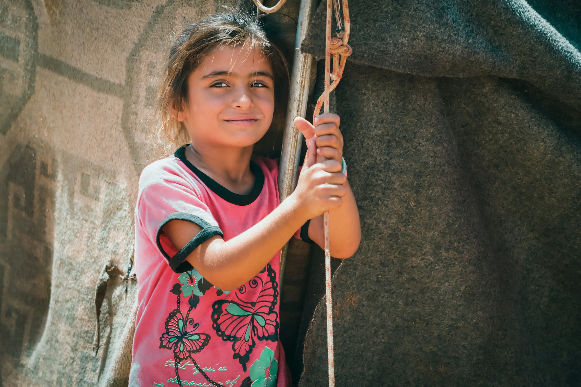A young girl holding onto a rope attached to a horse