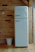 A white refrigerator freezer sitting on top of a wooden floor