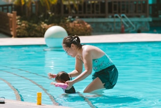 A woman and a child playing in a swimming pool