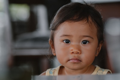 A little girl looking at the camera with a serious look on her face