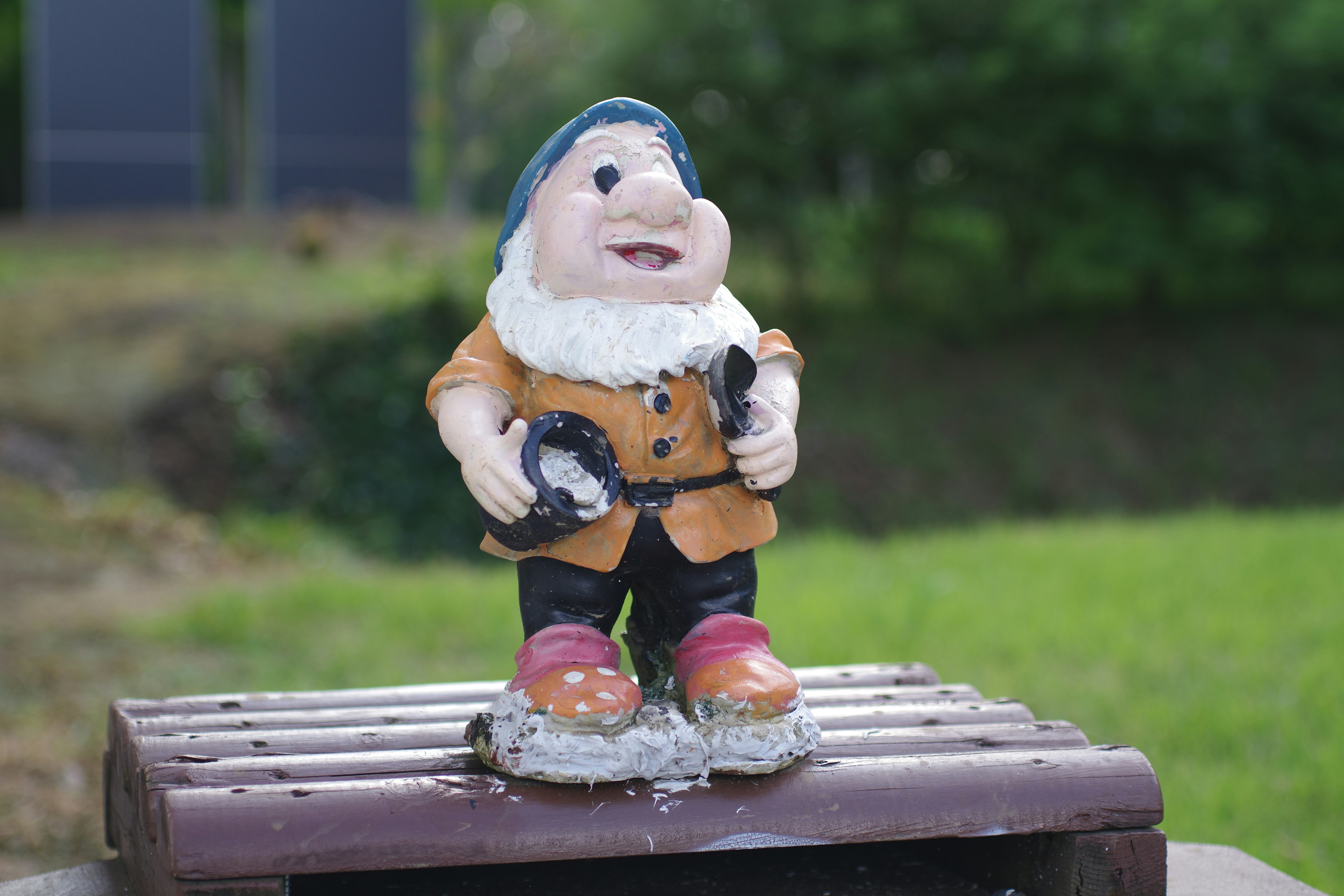 A gnome figurine sitting on top of a wooden box photo – Free Food
