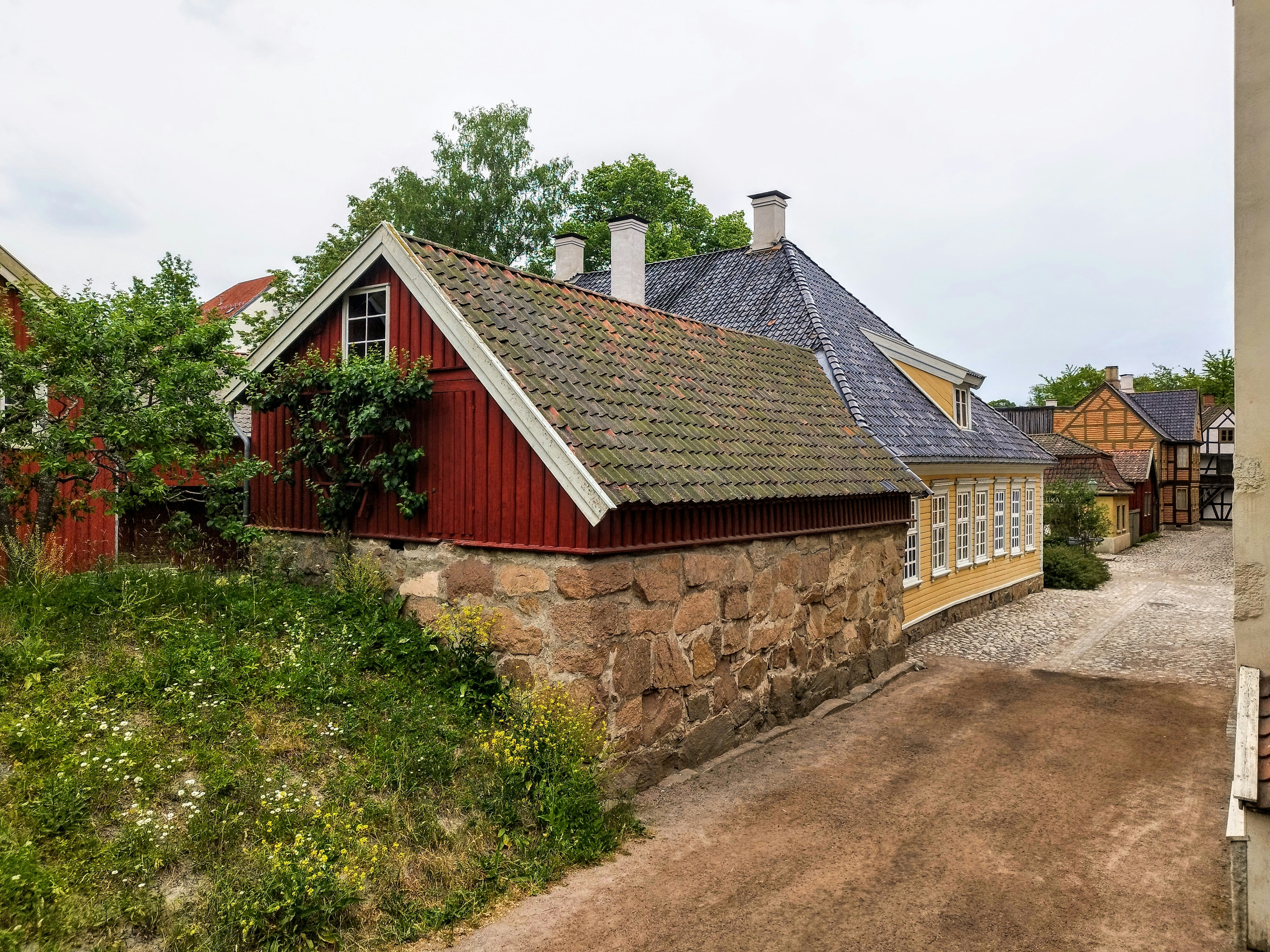 A red house sitting on top of a dirt road