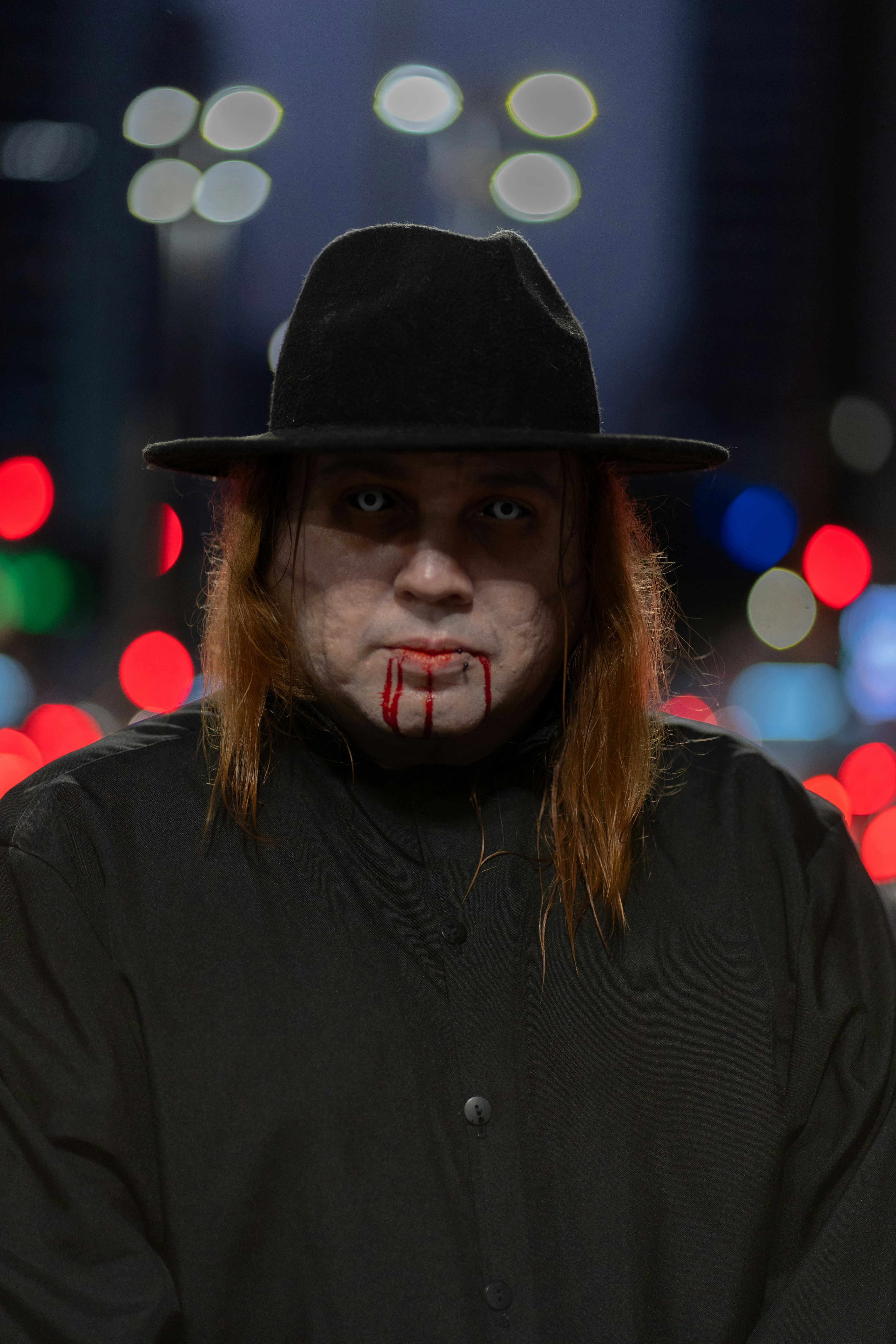 A man in a black hat with blood on his face