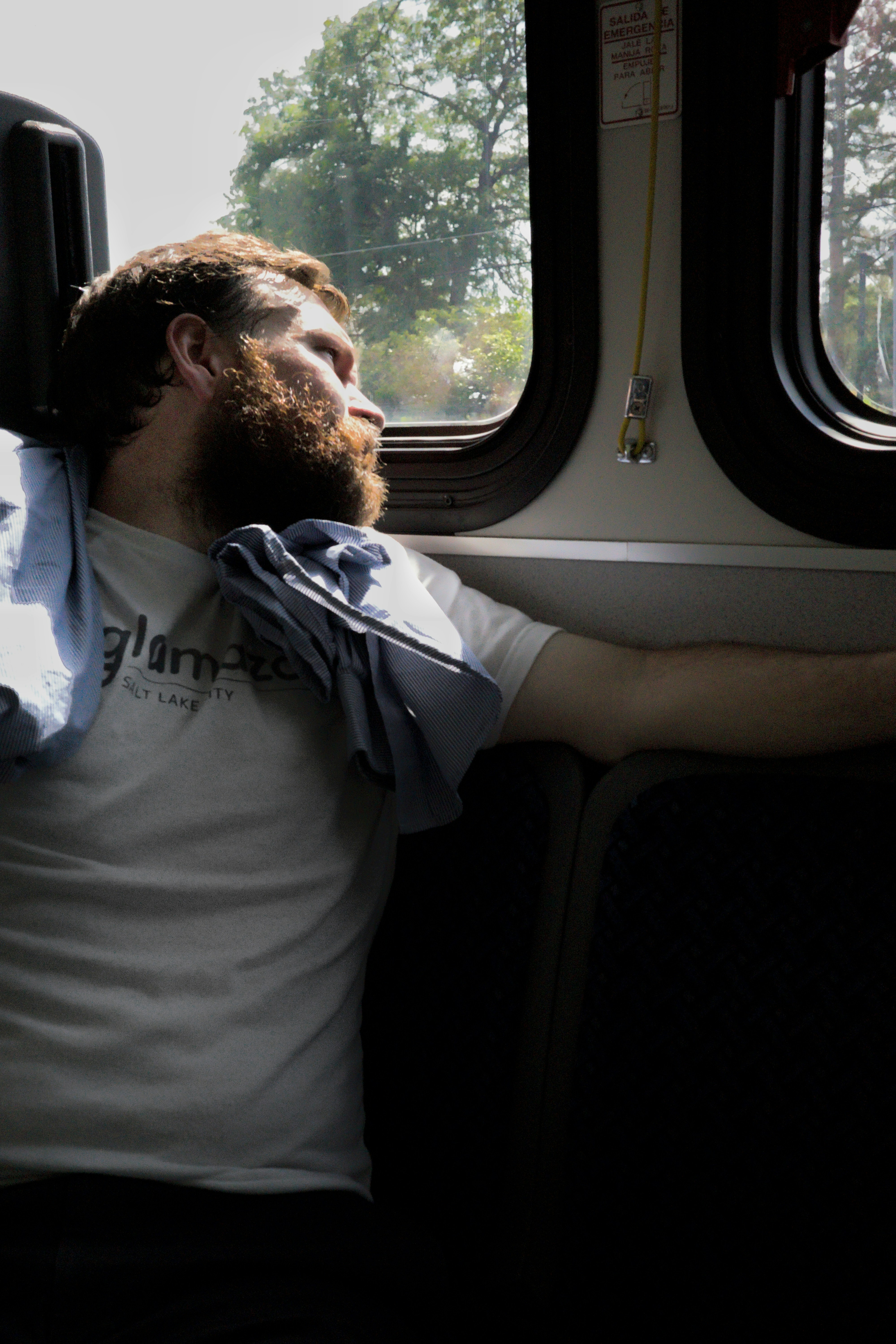 A man sitting on a bus looking out the window