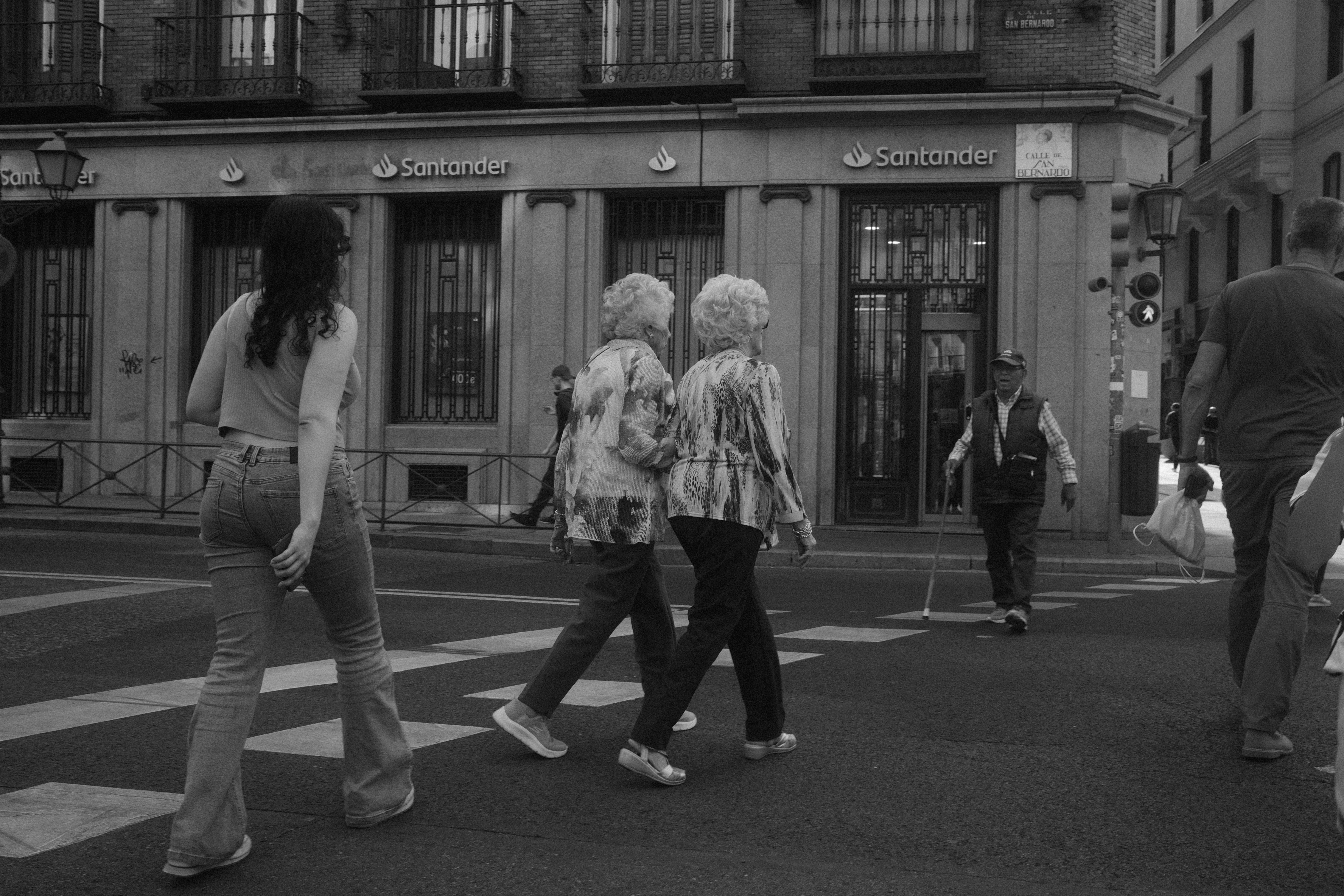 A group of people walking across a street