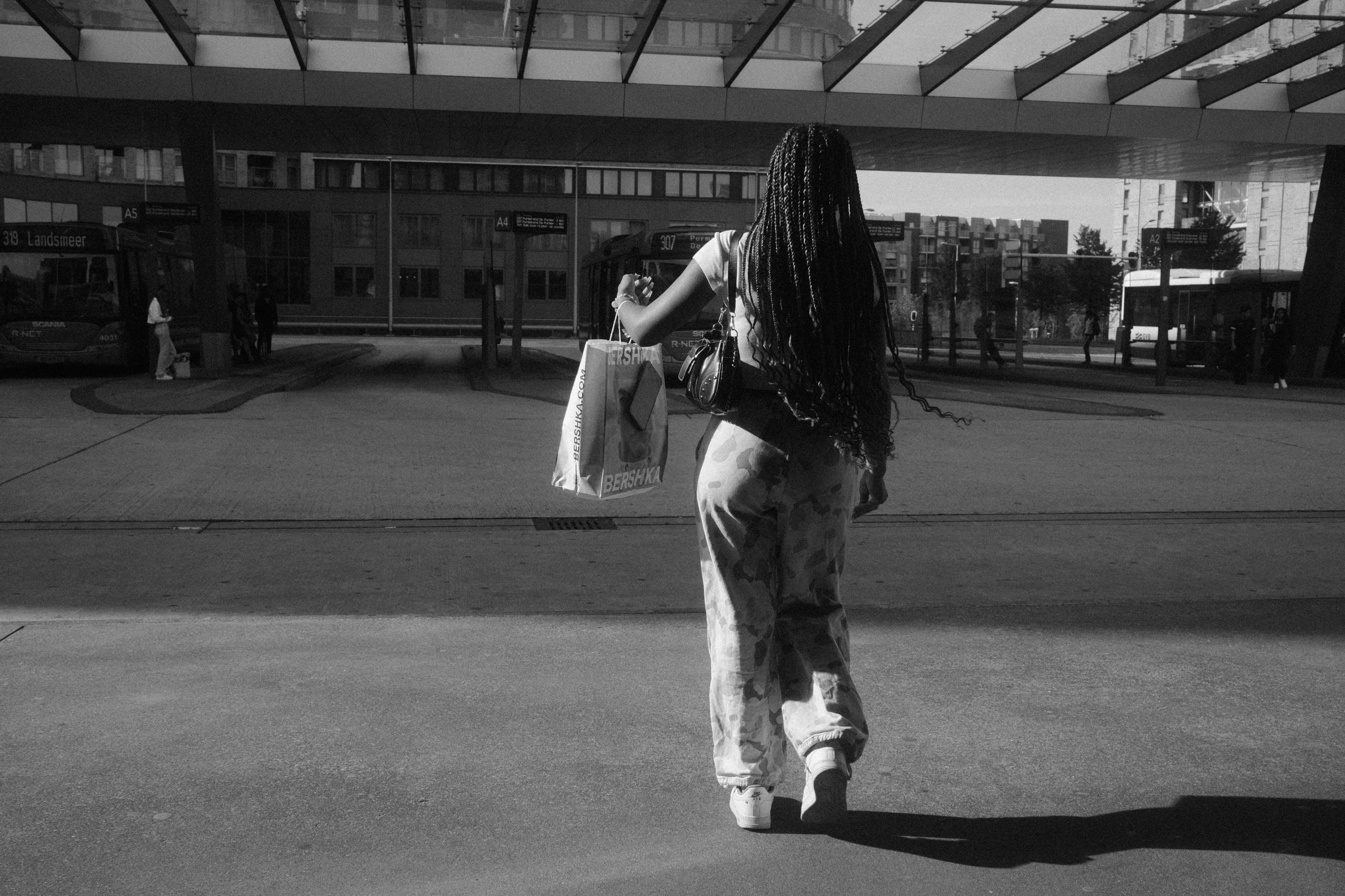 A woman walking down a street carrying a bag