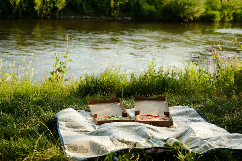 A blanket is set up on the bank of a river