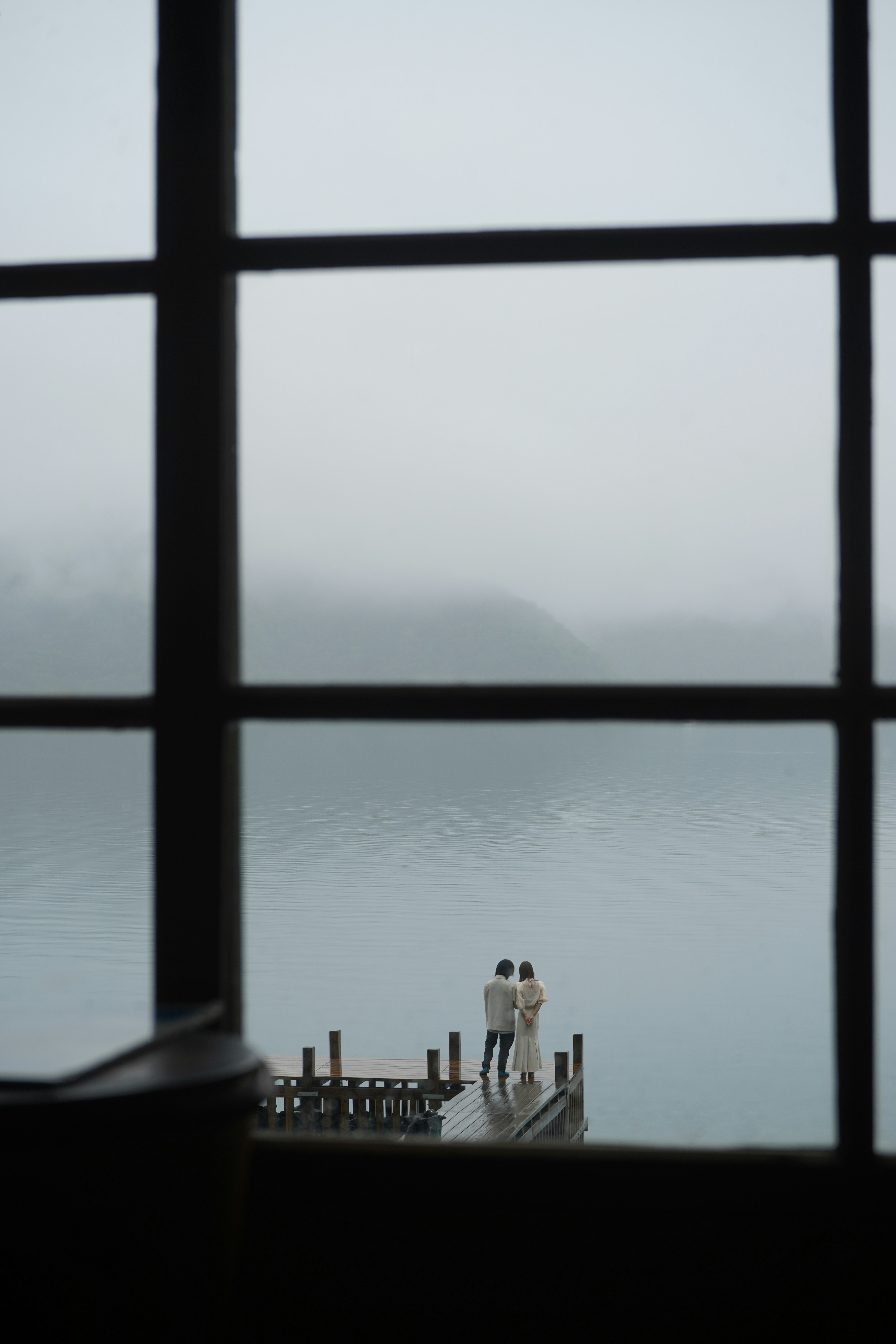 A couple of people standing on top of a pier