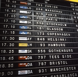Airport departure board showing flight destinations and times.