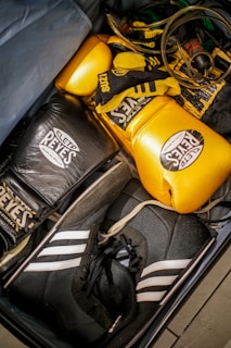 A suit case filled with boxing gloves and gloves