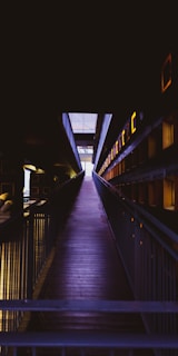 A wooden walkway leading to a building at night