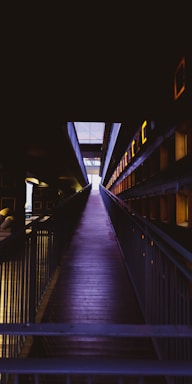 A wooden walkway leading to a building at night