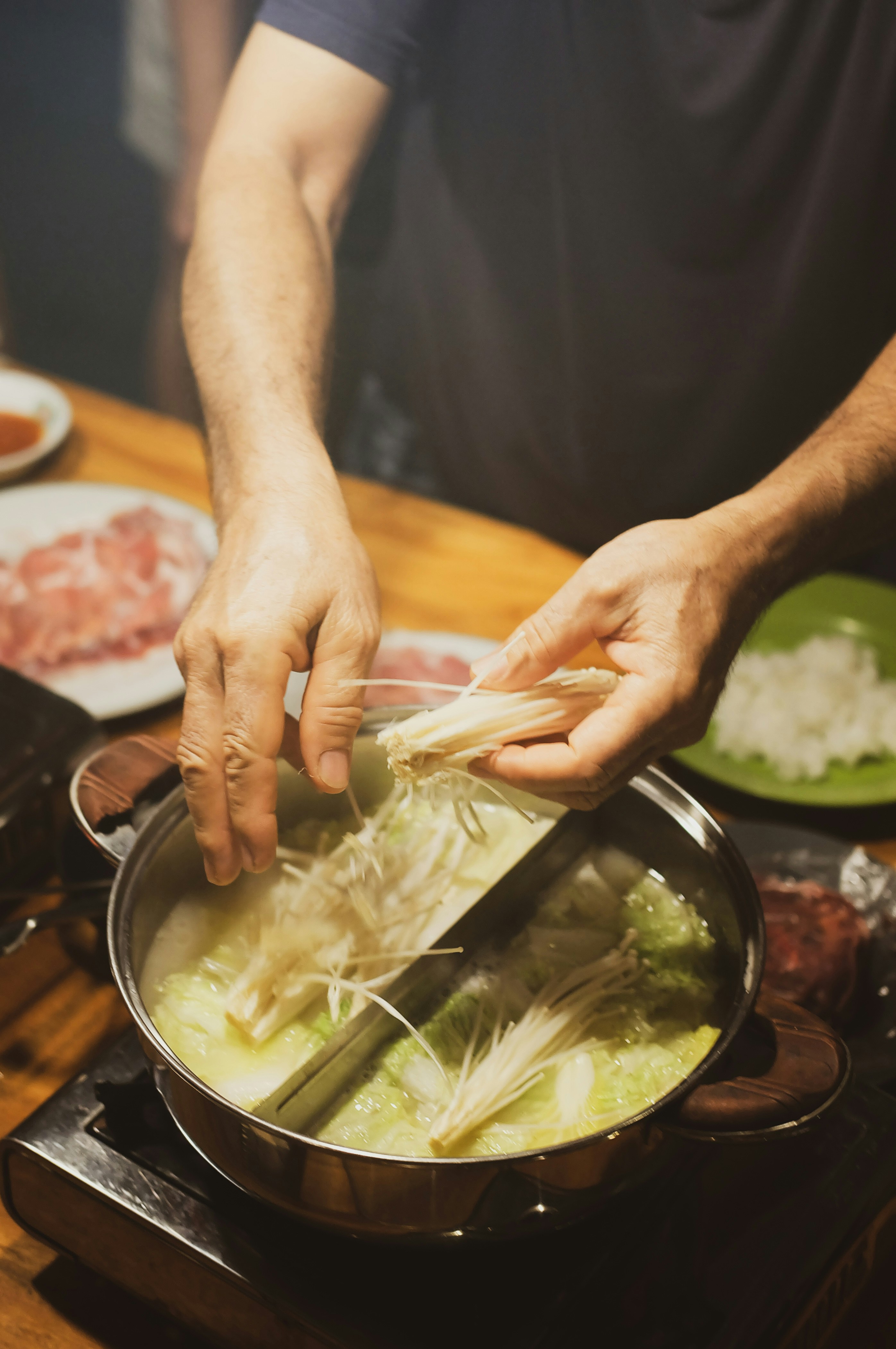 A man is cooking in a pot on the stove