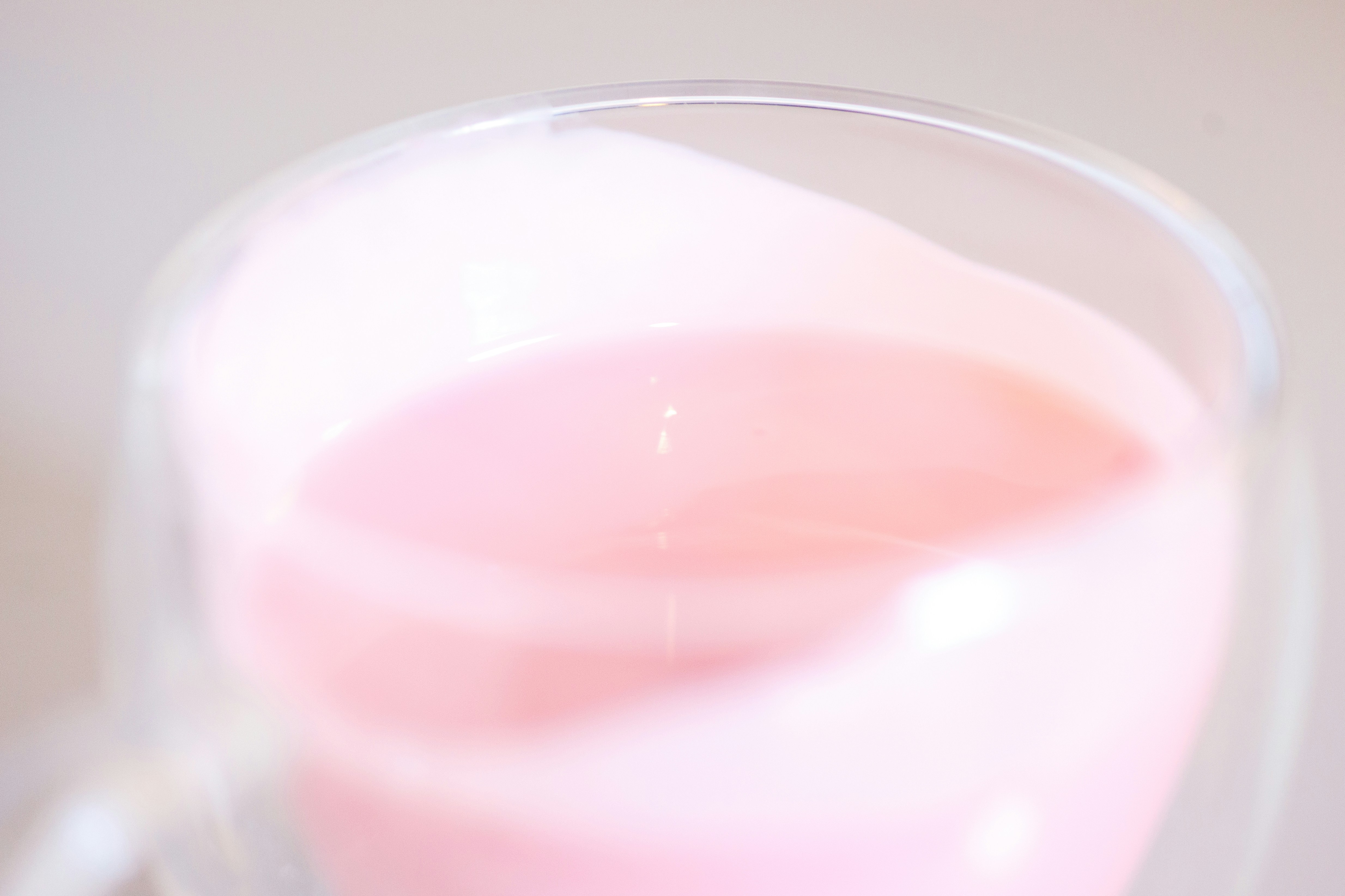 A close up of a pink liquid in a glass