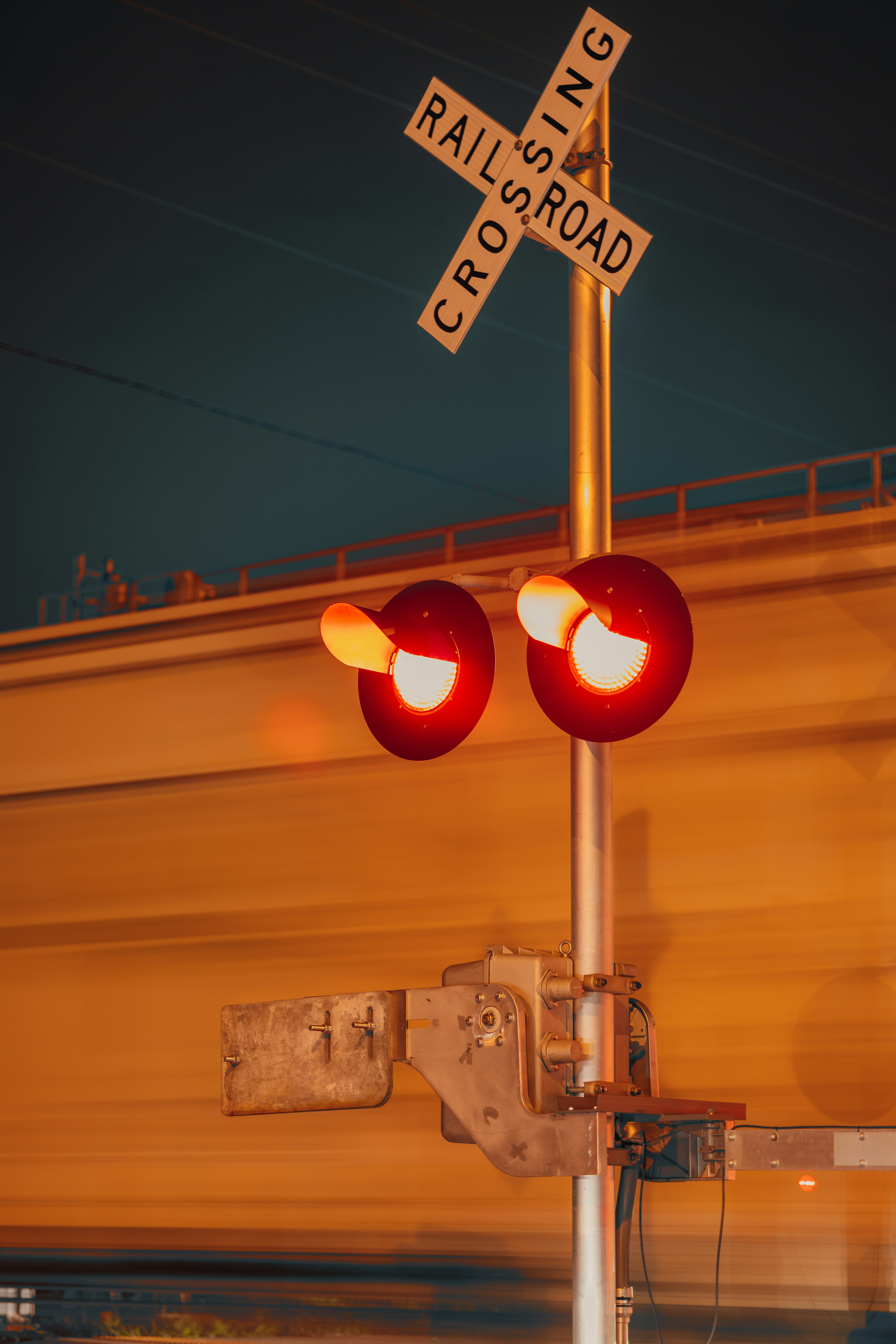 A railroad crossing signal with a train passing by