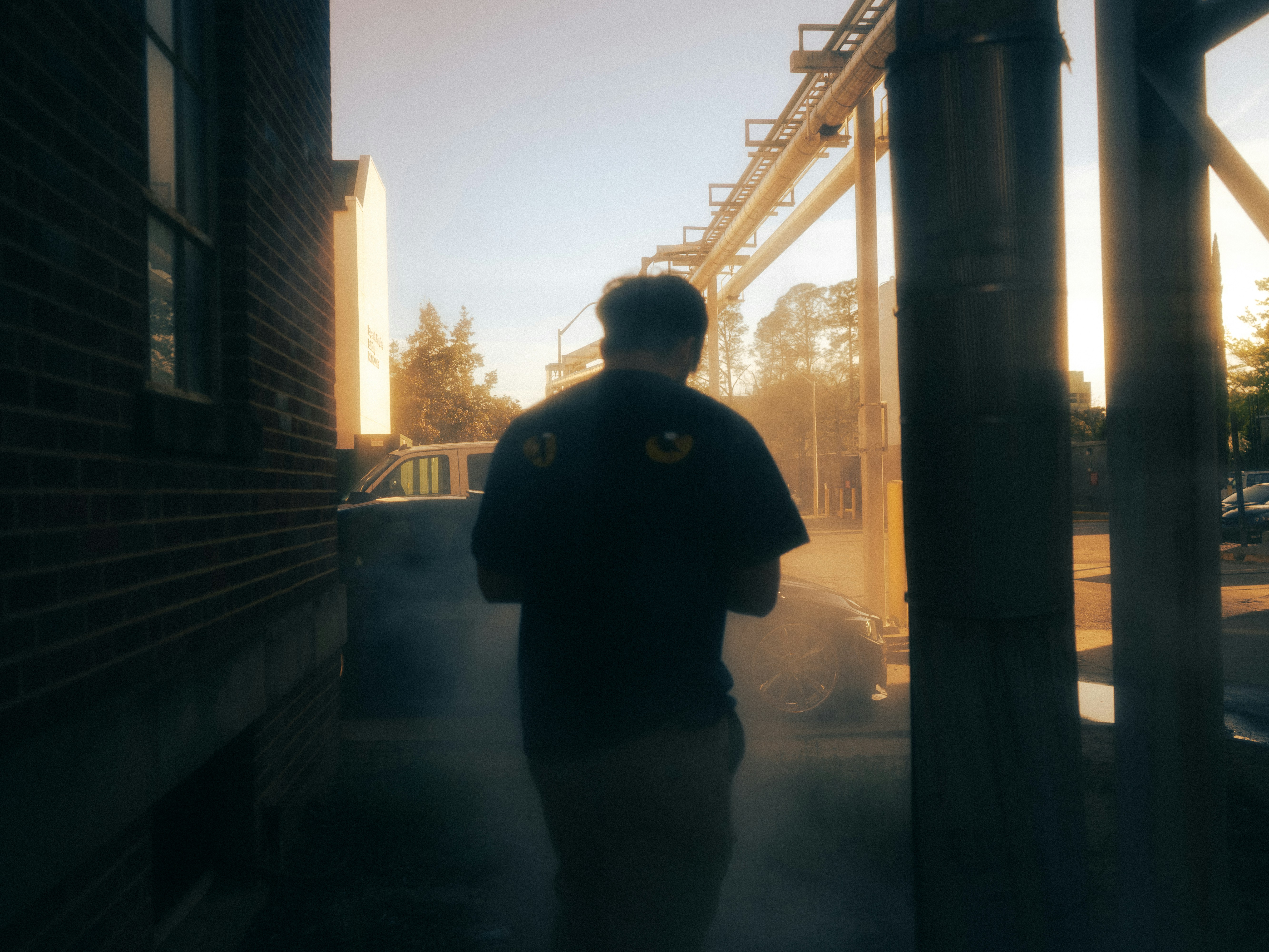 A man walking down a sidewalk next to a building