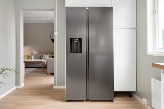 A refrigerator in a kitchen next to a window