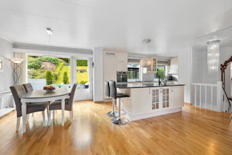 A large open kitchen and dining room with hardwood floors