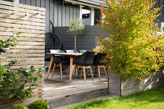 A patio with a table and chairs next to a fence