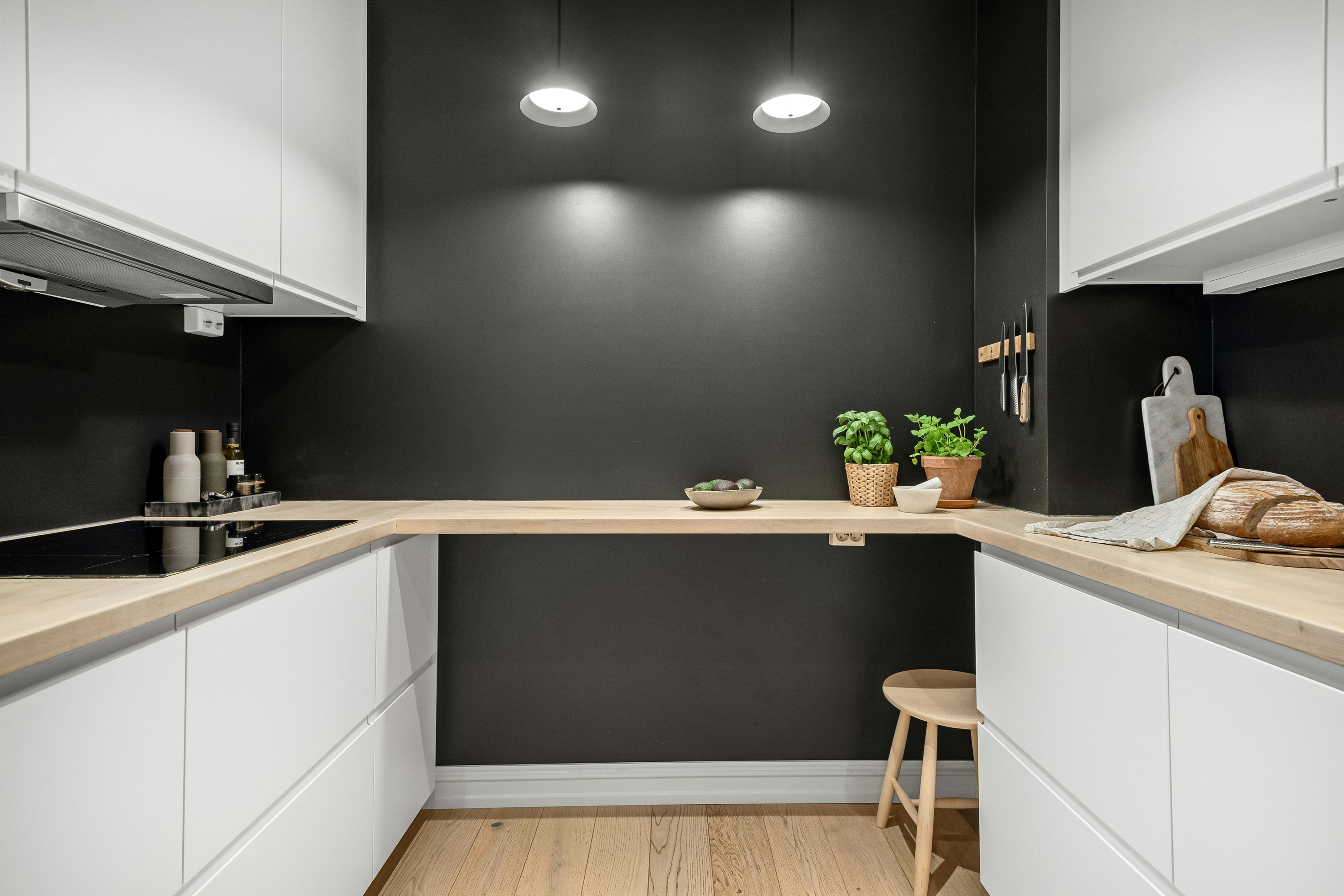 A kitchen with a wooden floor and white cabinets
