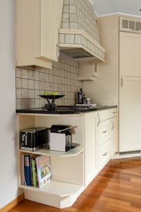 A kitchen with white cabinets and a wood floor