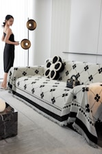 A woman standing in a living room next to a couch