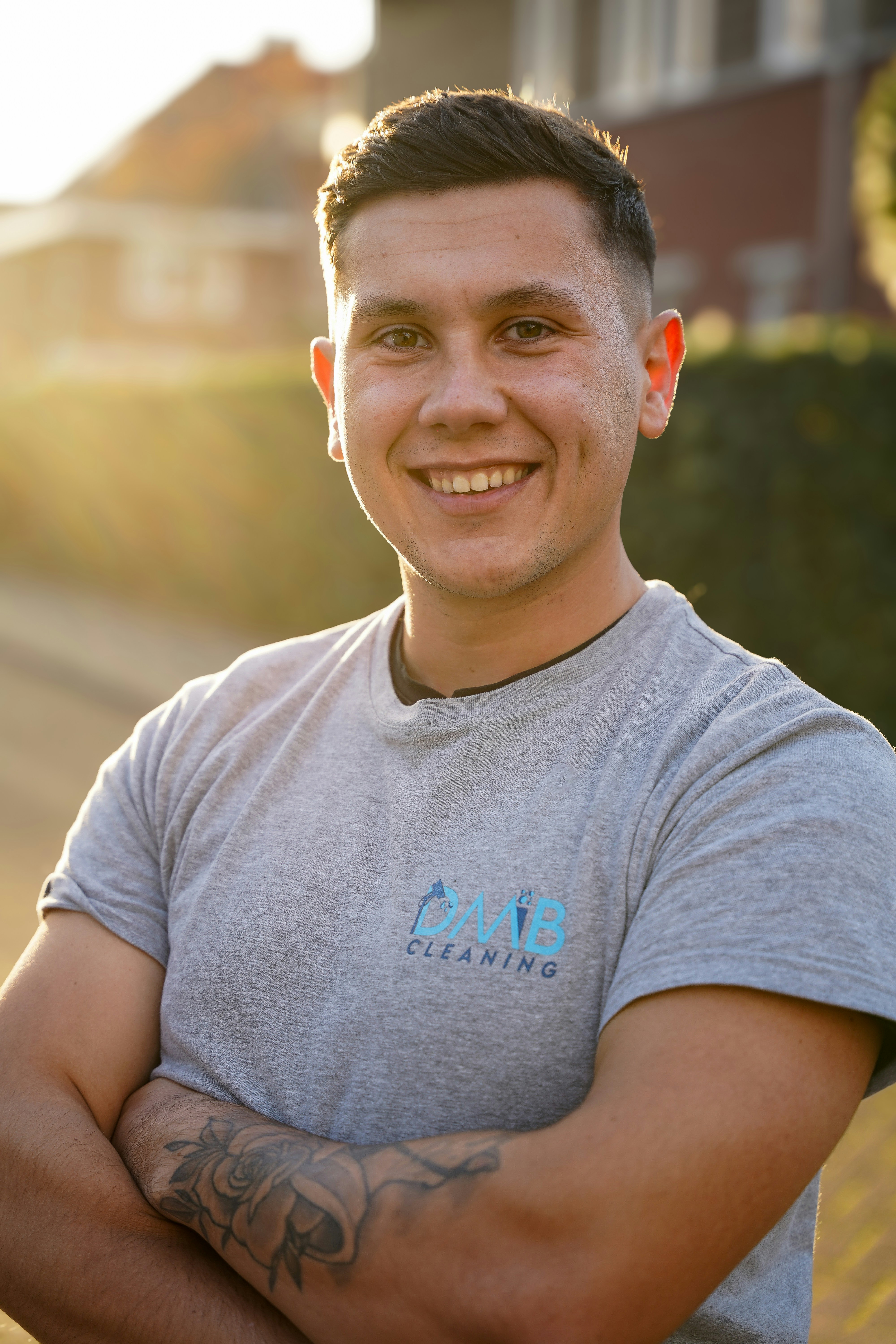 A man with his arms crossed standing in front of a street
