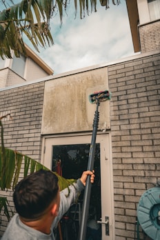 A man holding a basketball in front of a house