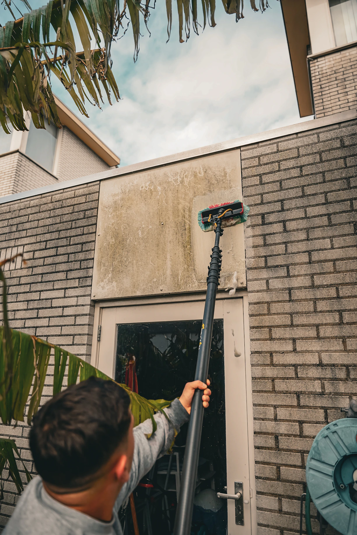 A man holding a basketball in front of a house
