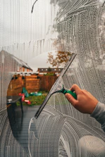 A person is drawing a picture on a window