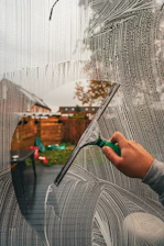 A person is drawing a picture on a window