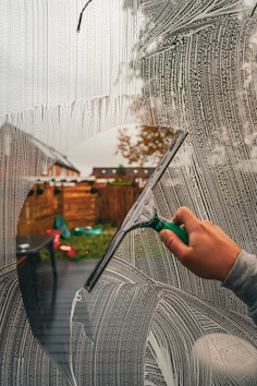 A person is drawing a picture on a window