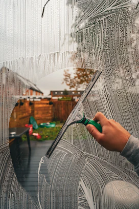 A person is drawing a picture on a window
