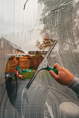 A person is drawing a picture on a window