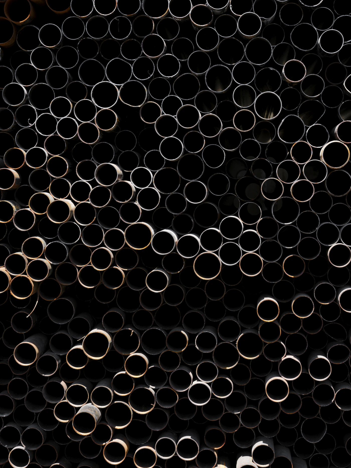 Bundle of larger hollow steel pipes with circular ends visible