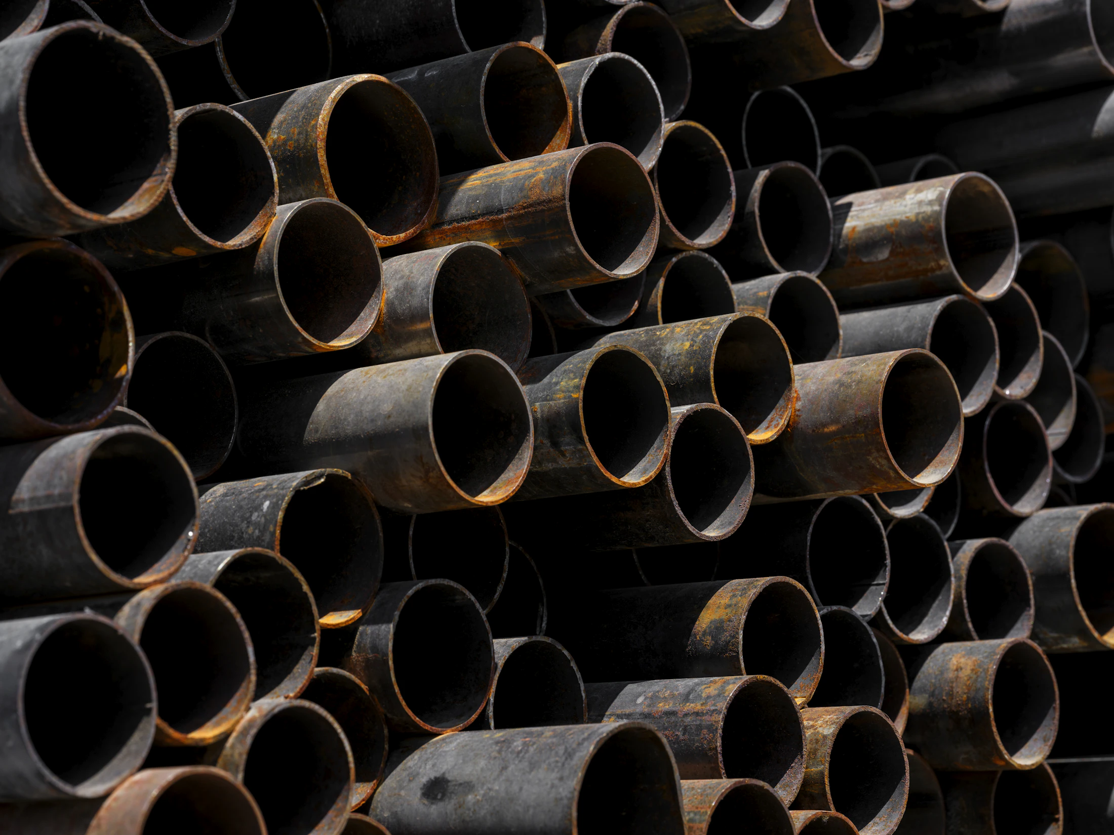 Stacked round steel pipes with hollow circular cross-sections visible