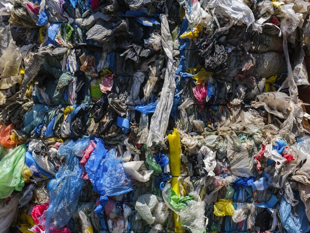 Montaña de residuos plásticos acumulados que muestra el impacto de la contaminación por plástico convencional