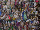 A large pile of garbage sitting next to a metal fence