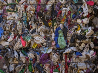 A large pile of garbage sitting next to a metal fence