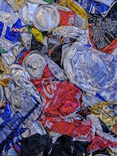A pile of soda cans and cans of soda